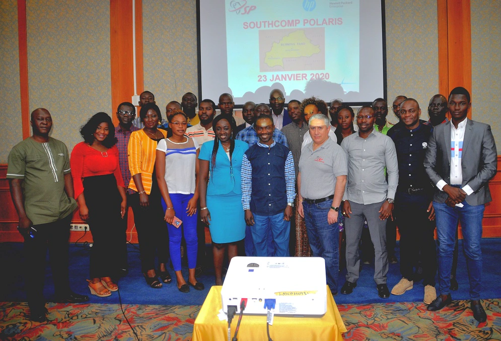 A group photograph with a presentation screen seen in the background