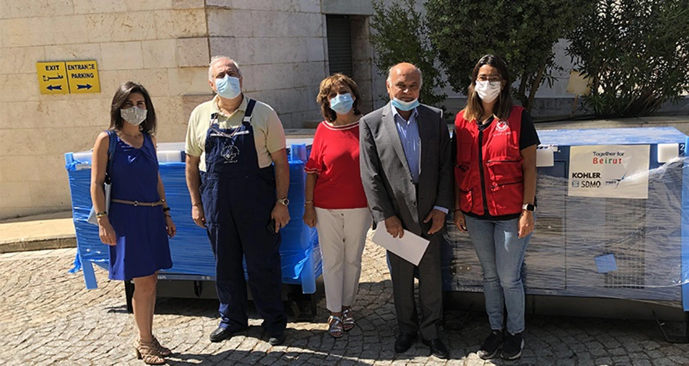 a group of people standing in front of generating equipment