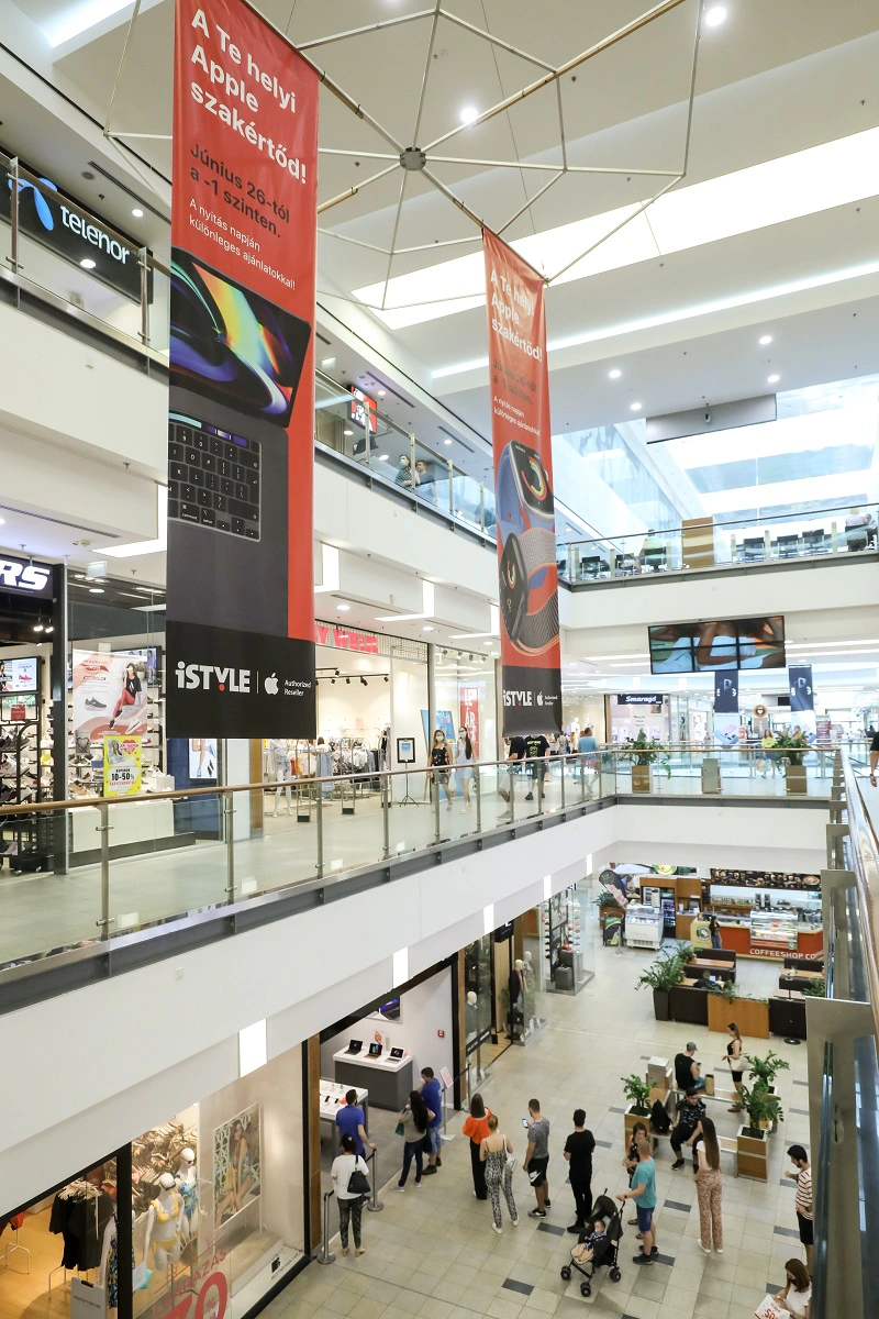 shows a large shopping mall with an iSTYLE banner hanging from the ceiling.