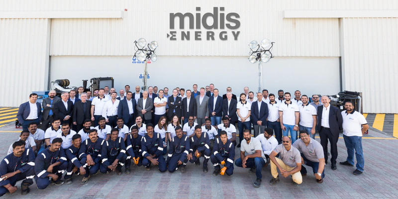 a large number of people are seen in a big group photo in three ranks with the words Midis Energy seen on the wall behind them