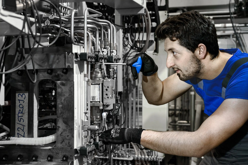 shows a man working a machine tool