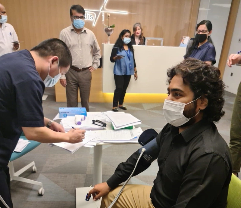 shows a man receiving a vaccination as others look on