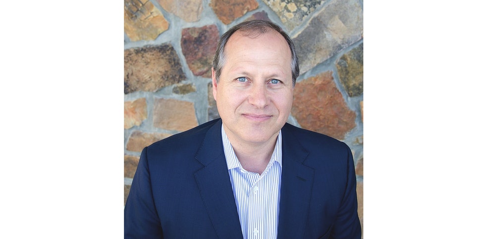 Head and shoulders photo of a man in a suit