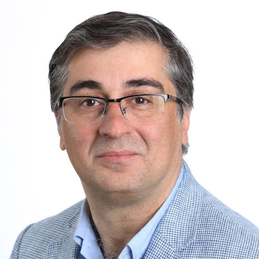 Head and shoulders photo of a man with glasses in a suit