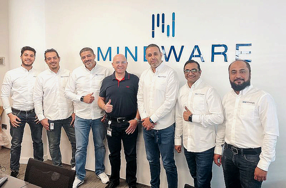 seven men stand side by side in front of a Mindware logo on the wall