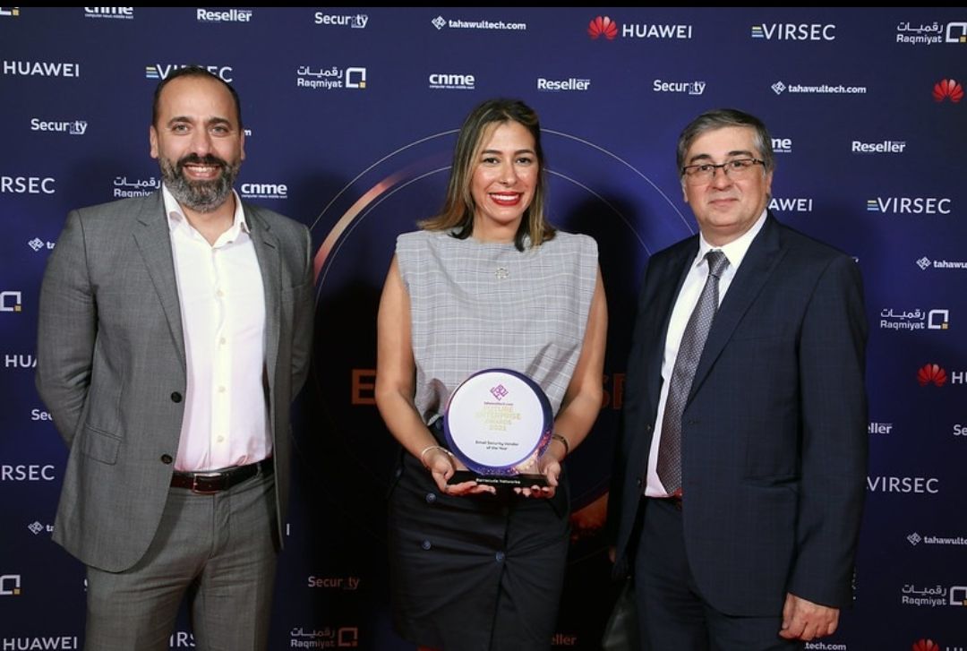 three people at an award event show their trophy