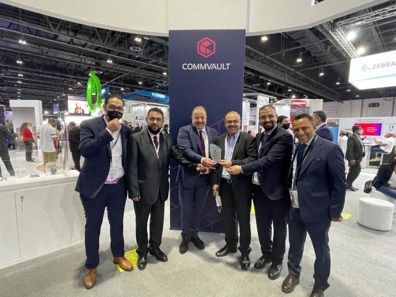 six men are seen at an exhibition stand handing over an award