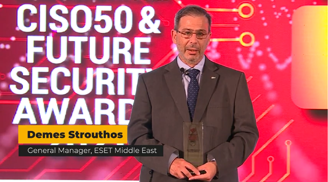 a man is seen on a presentation stage as he accepts a trophy