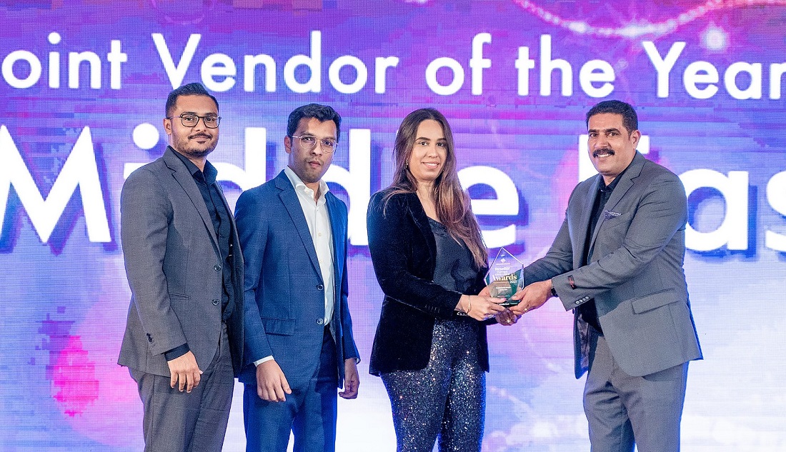 three people on a presentation stage accept an award