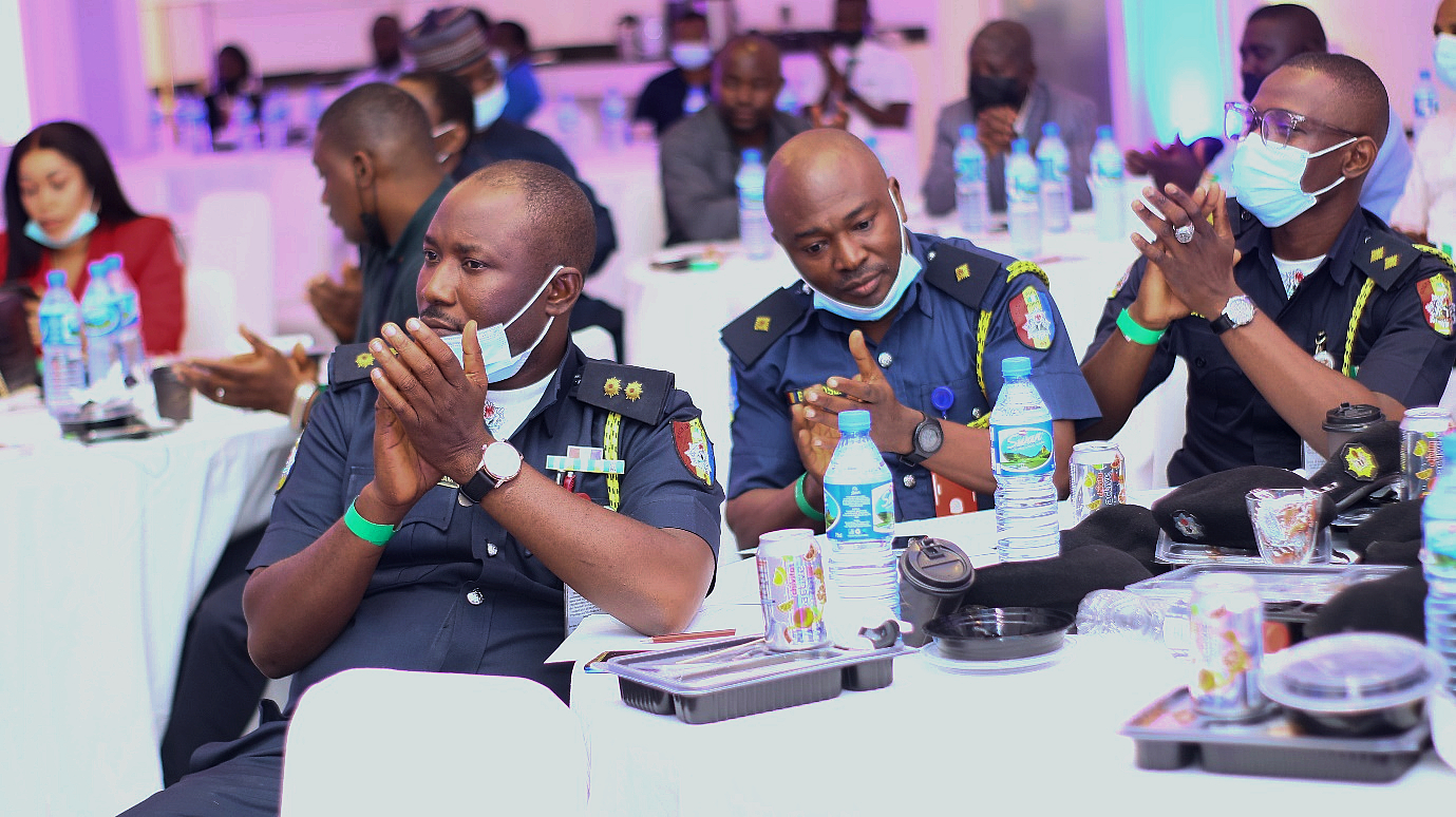 people at a table are seen applauding a speaker