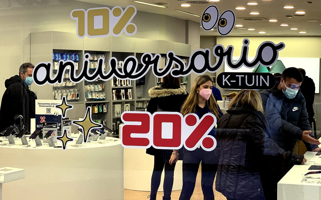 looking inside through a shop window, people can be seen examining hi tech products