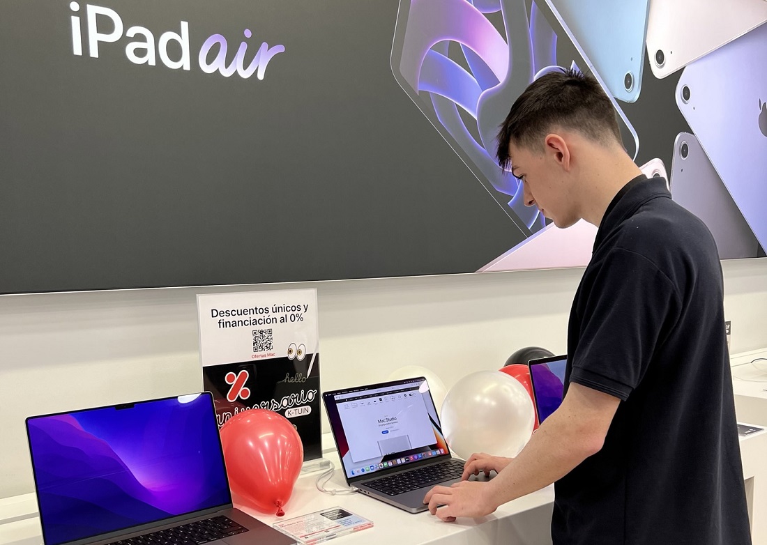 : un jeune homme regarde un iPad sur un site de vente au détail.