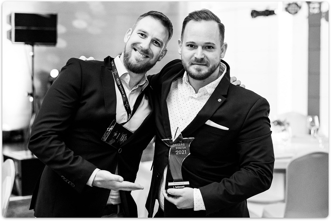 two men seen with a trophy in a presentation event