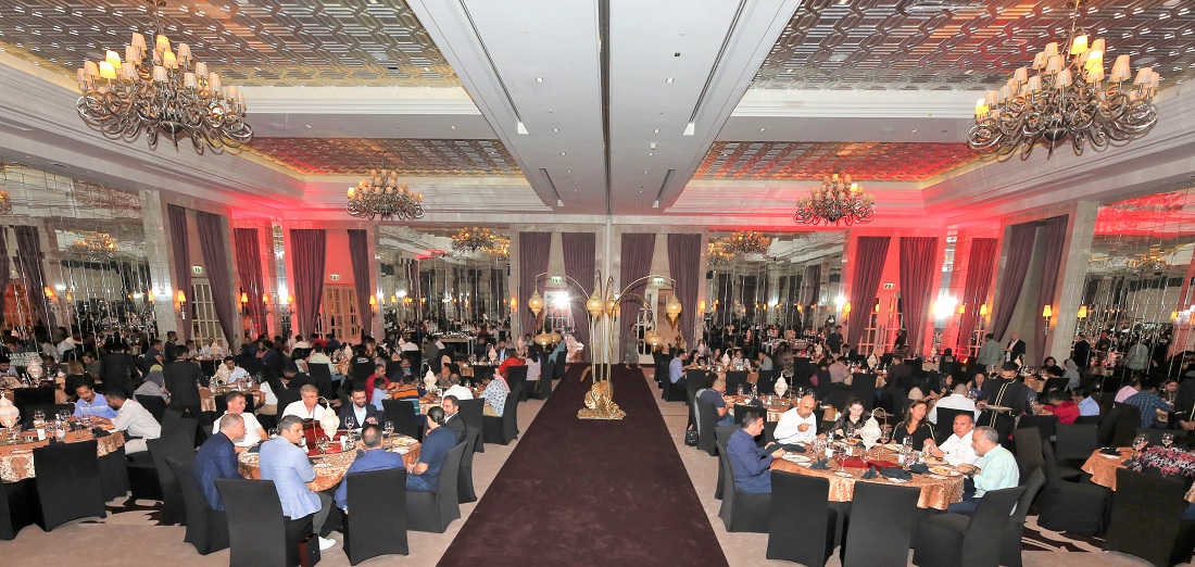 large room with chandeliers hanging from the ceiling and many tables filled with diners