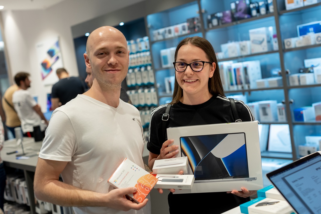 deux personnes devant un bureau de vente au détail dans un magasin Hi-Tech