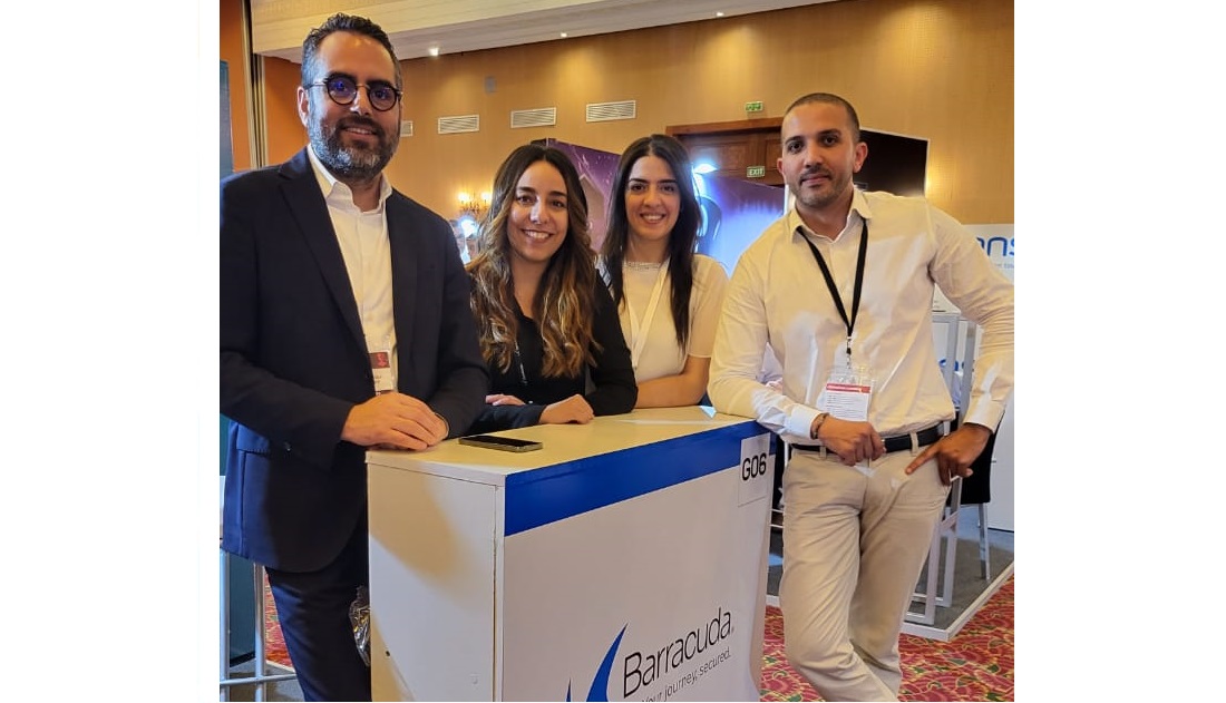 deux hommes et deux femmes se rencontrent sur un stand d'exposition