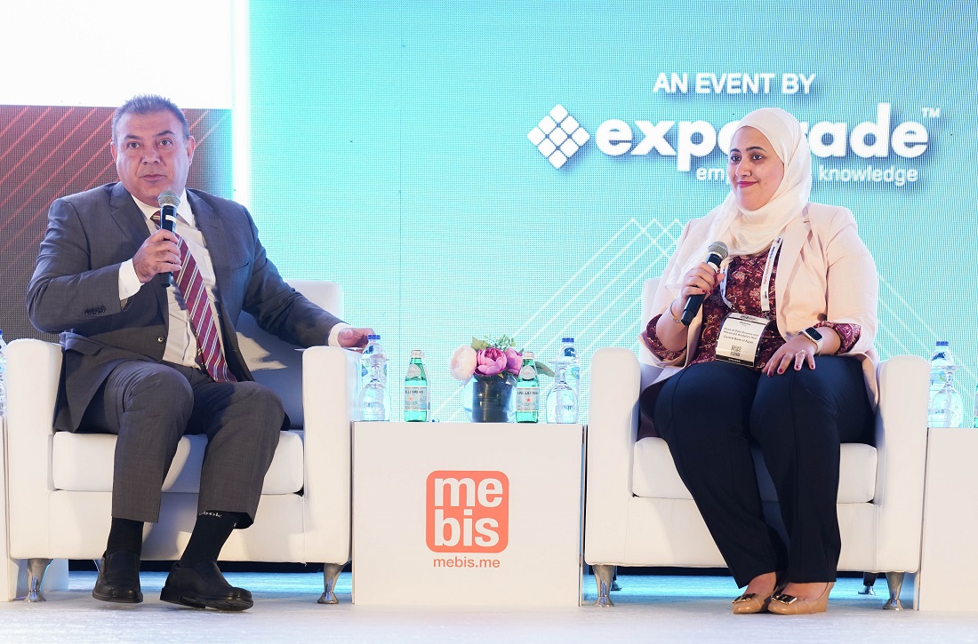 a man and a woman are on a stage and are talking with an audience