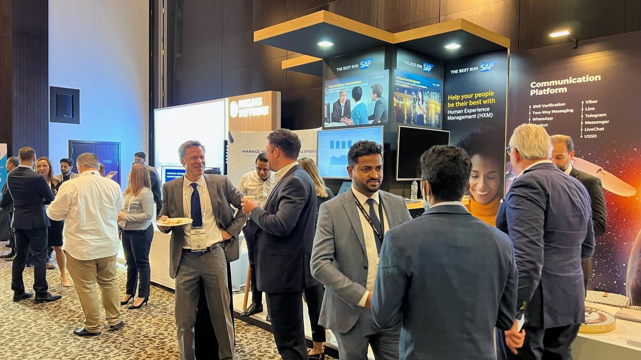 A group of people seen in front of an exhibition stand