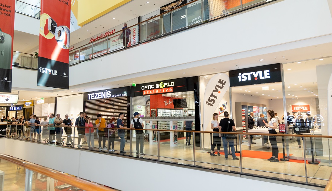 une file d'attente de personnes dans un centre commercial à l'extérieur d'un magasin de haute technologie