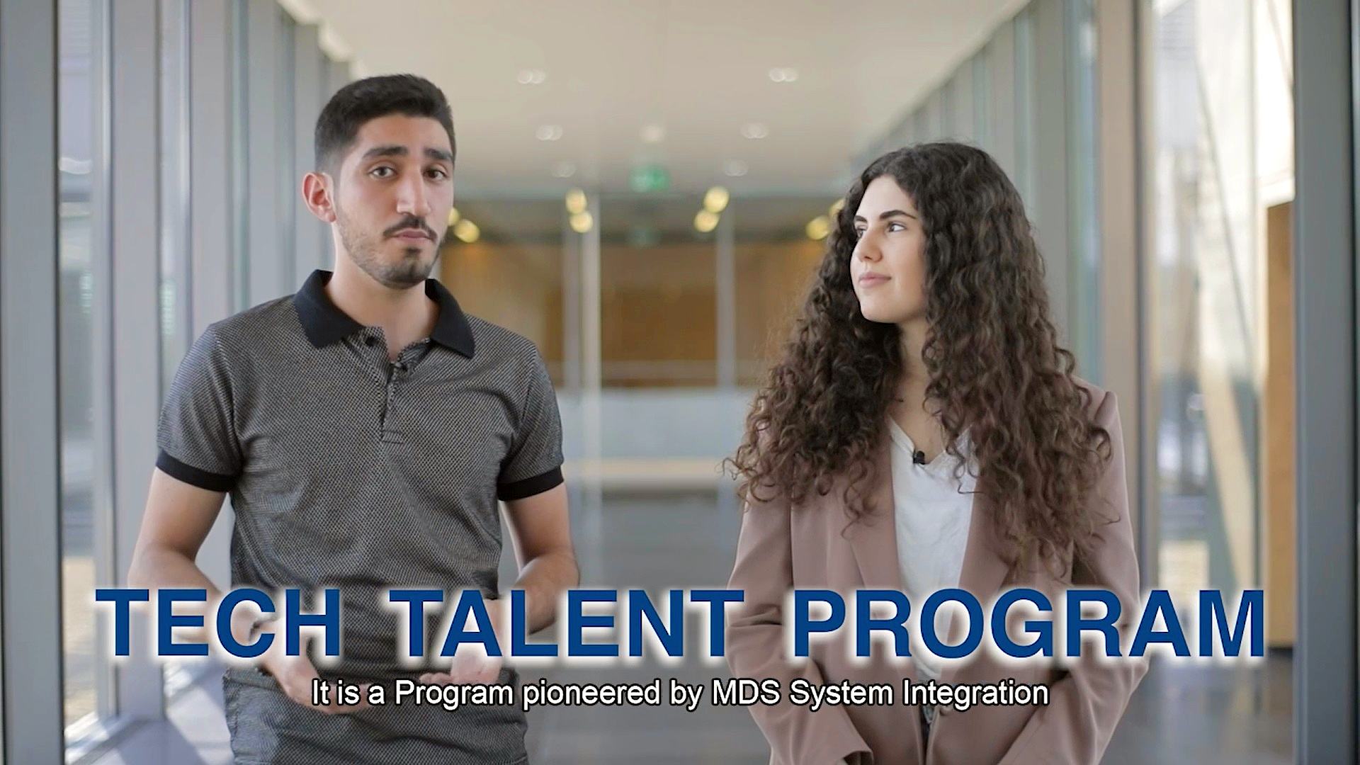 two young people are seen on a video still with the words Tech Talent Program acorss the lower part of the screen