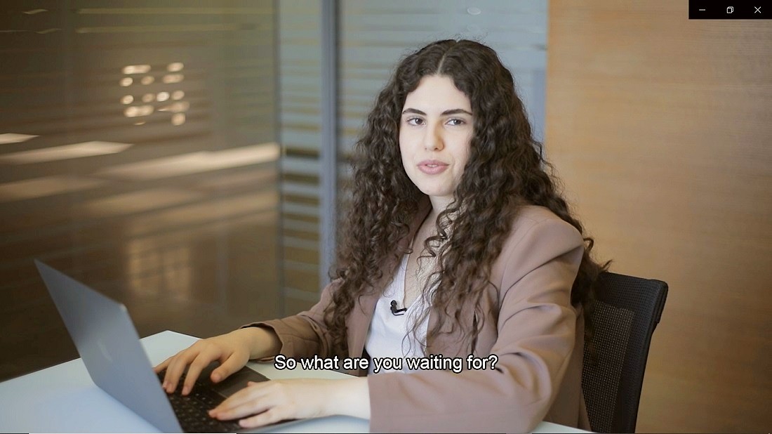 une jeune femme est vue dans un bureau devant un ordinateur portable avec un sous-titre sur l'écran qui dit, alors qu'attendez-vous ?