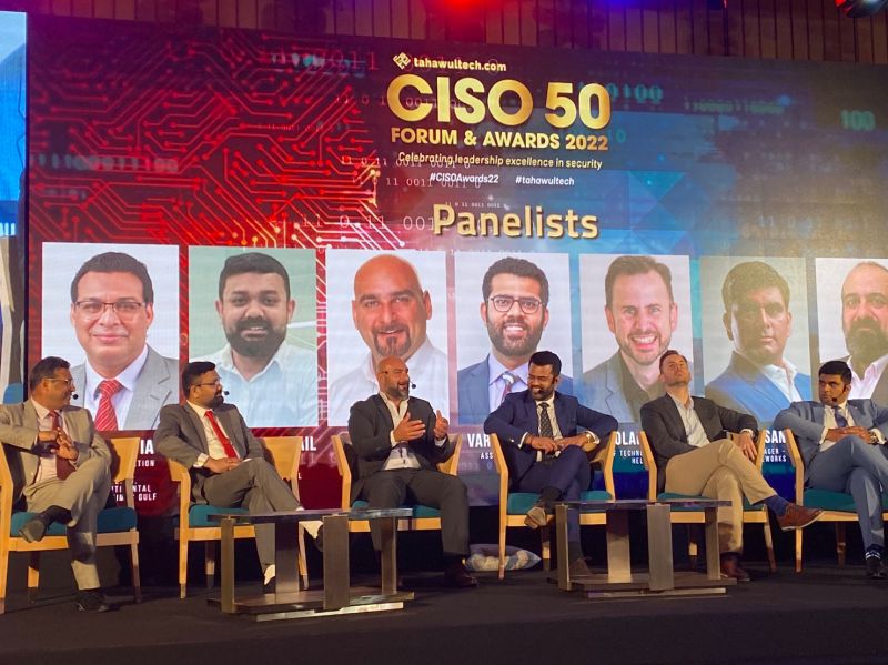 a group of men on stage with a projected backdrop