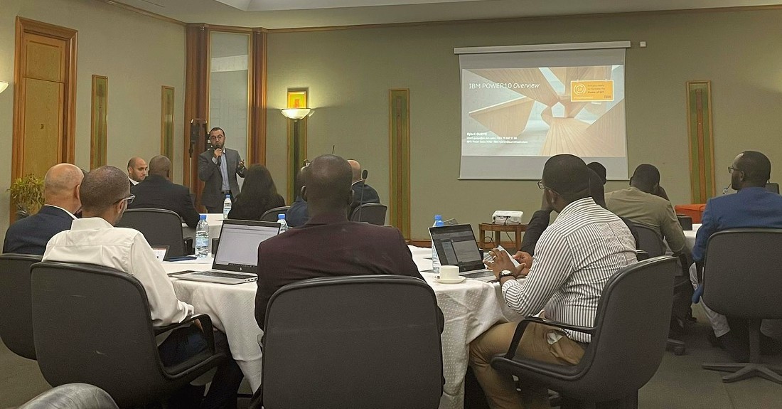 a man presents to a room full of people who are sitting in the foreground