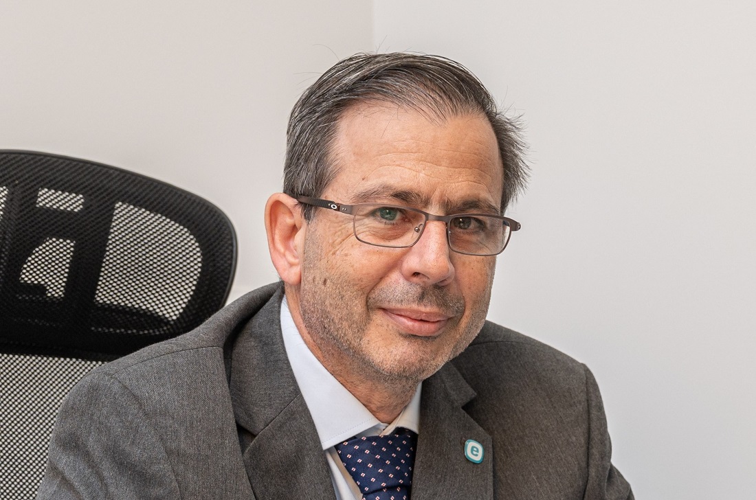 Head and shoulders photo of a man in a suit wearing a tie