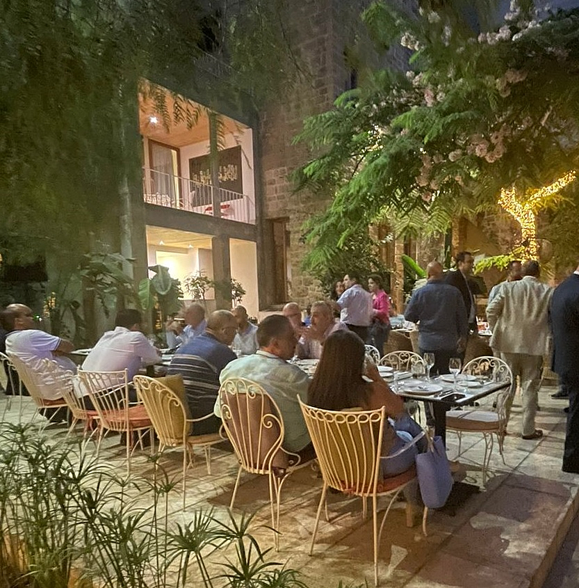 a group of people are sitting at tables and dining and talking