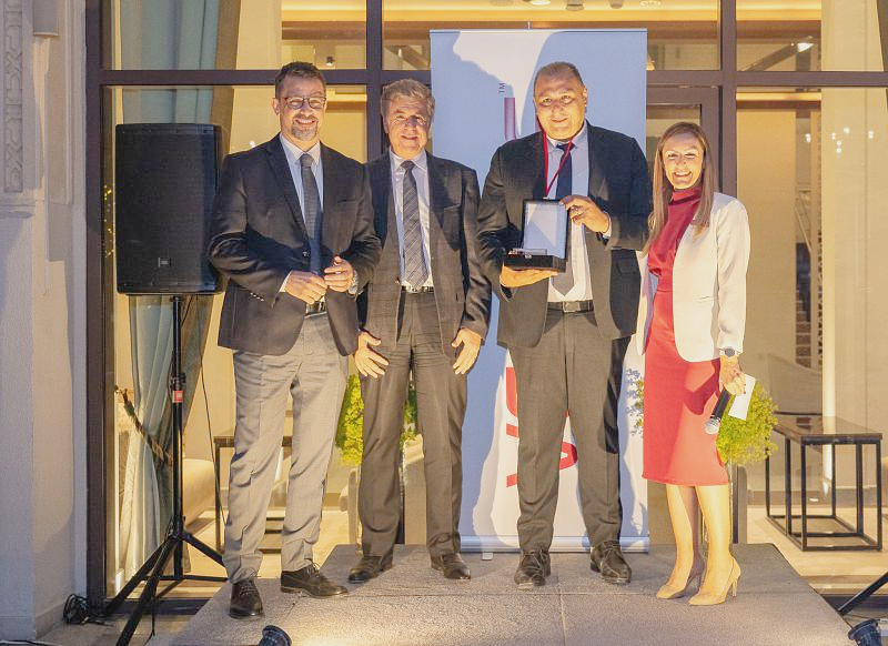 four people in a group photo holding an award trophy