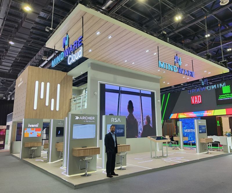 a man stands in front of a large hi tech exhibition stand