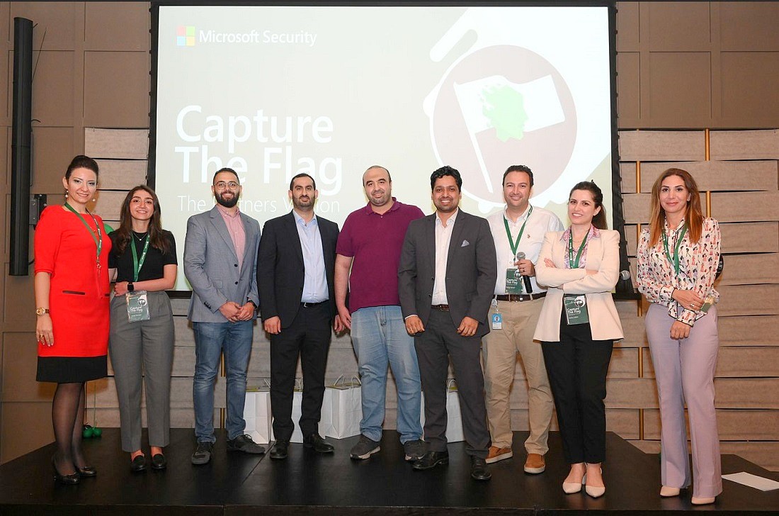 a group photo against a backdrop spelling the words Capture the Flag