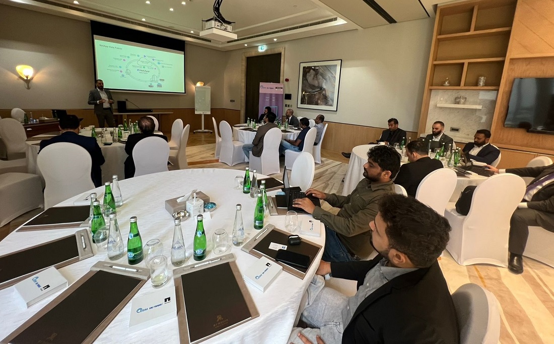 a room full of people can be seen with a person presenting at the top of the room