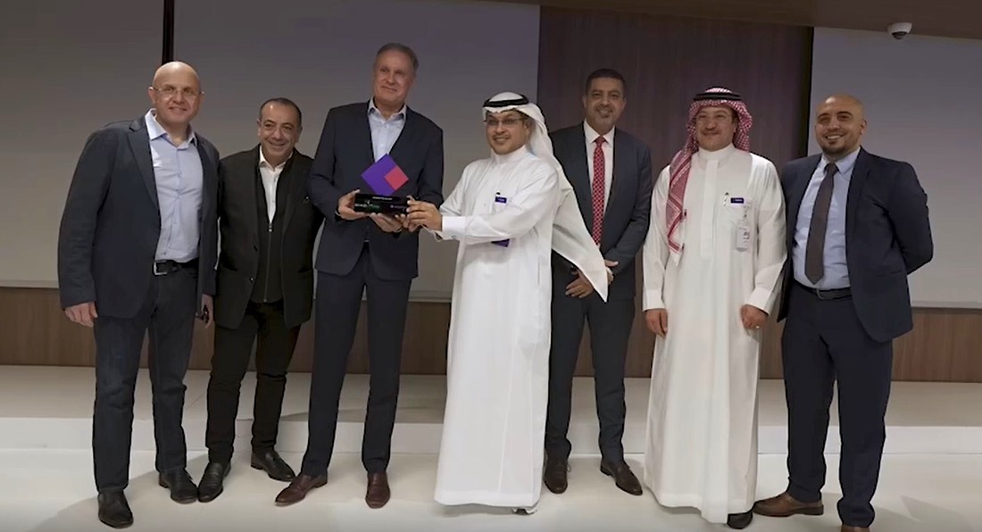 Seven men are seen standing together as a trophy is handed over