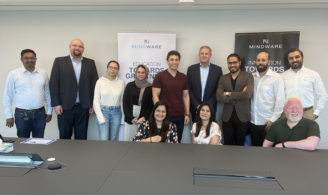 un groupe de personnes assises derrière une table et souriant à la caméra