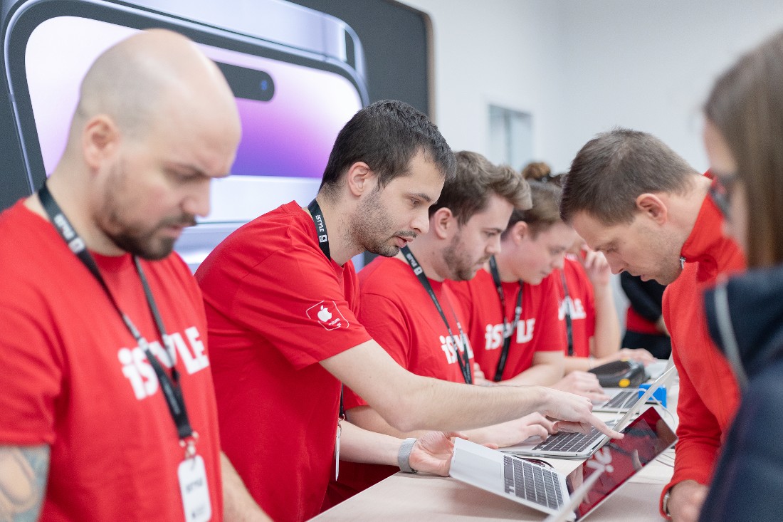 six people are seen at a tech store service counter