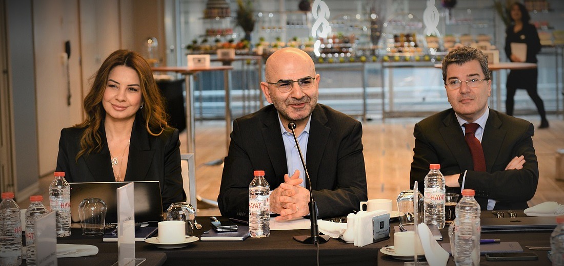 3 people sitting at a desk at an executive event