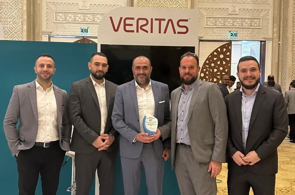 five men in suits celebrate an award with one of them holding a trophy