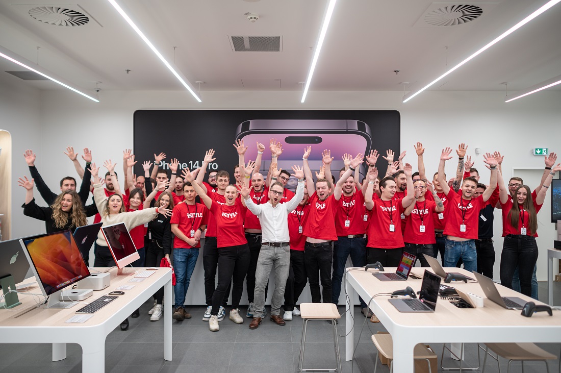 un grand groupe de personnes dans un magasin de haute technologie, tous portant des t-shirts rouges