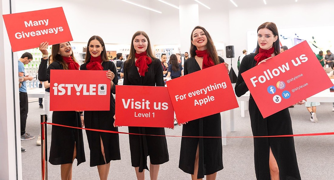 five women hold red placards with text on them