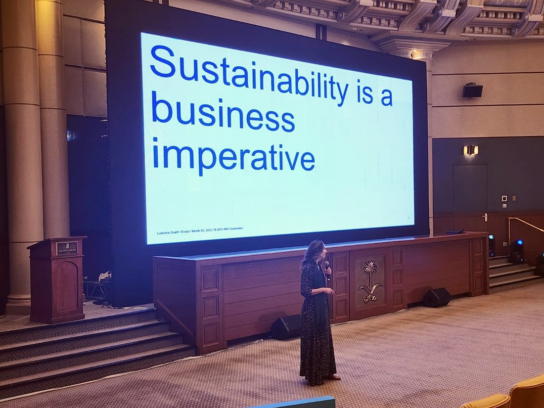 a woman is presenting in front of a digital screen