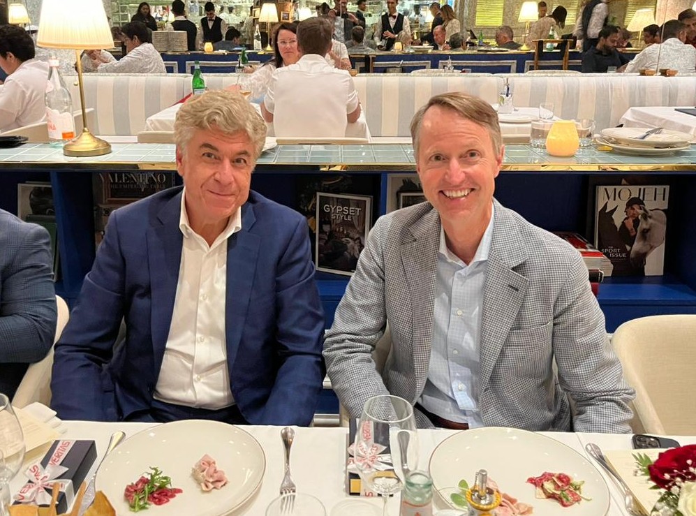 two men sit at a dinner table