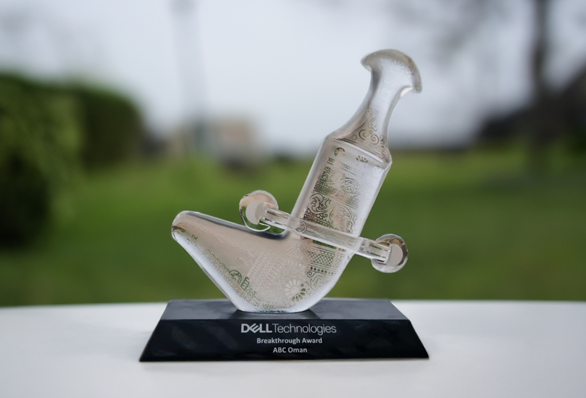 a glass trophy is seen in an outdoor setting on a plinth