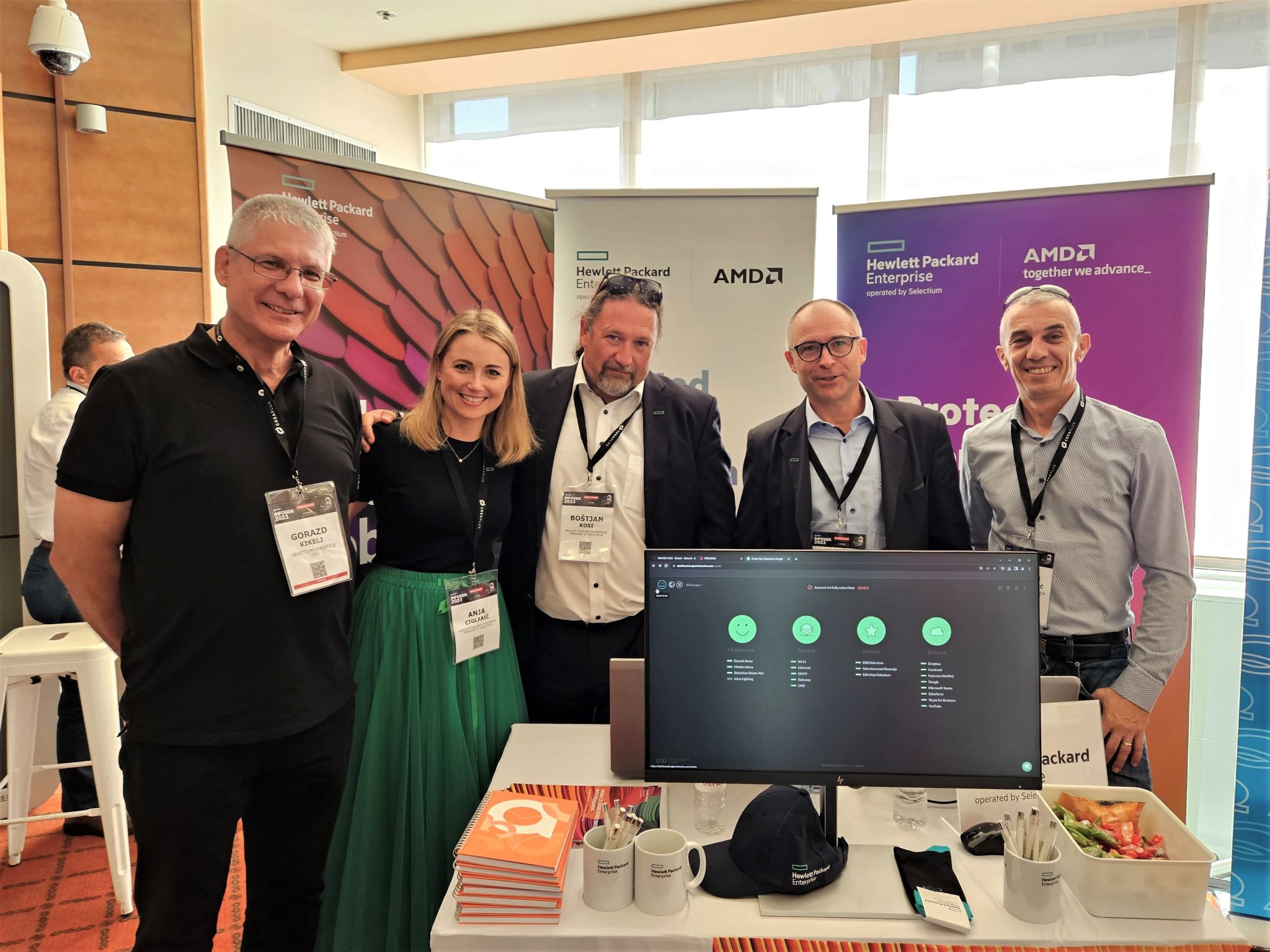 a group of five people are seen at an exhibition stand