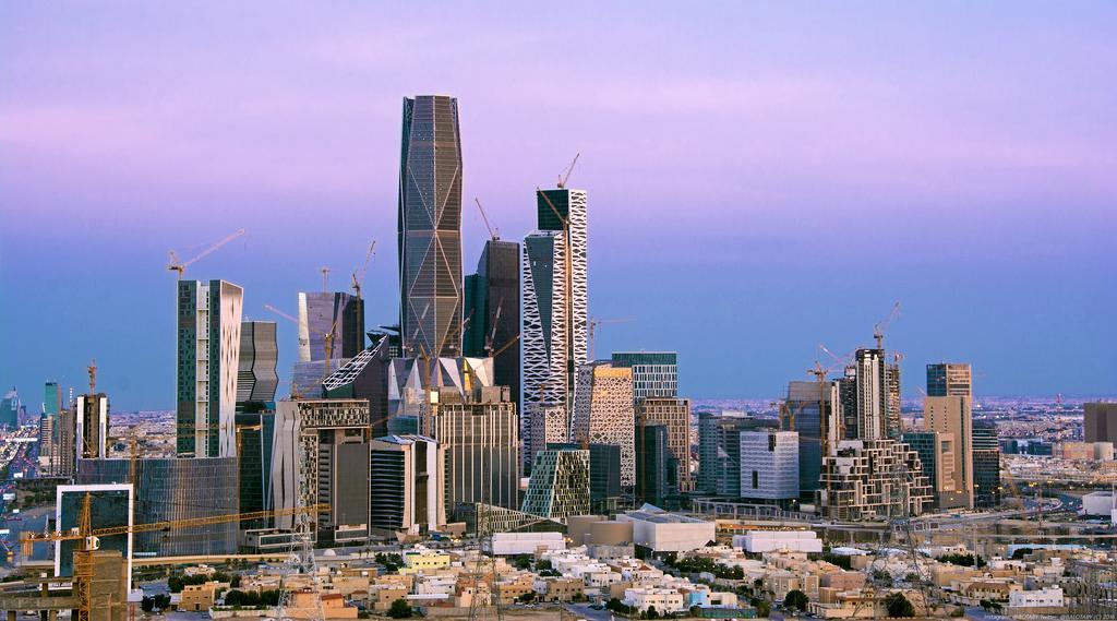 a modern city skyline with many buildings of different heights seen against a sunset
