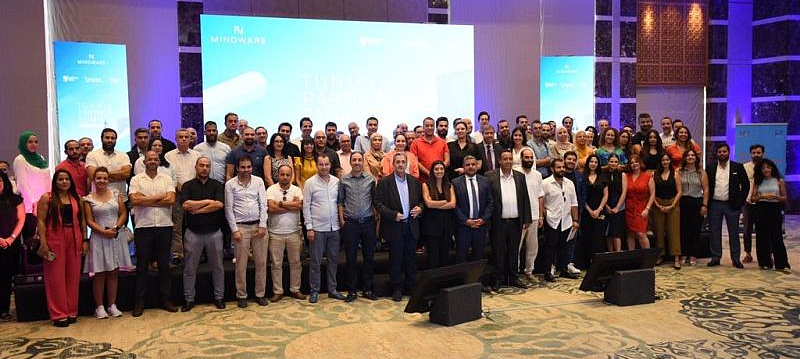 photograph of a large group of people standing in front of a presentation screen