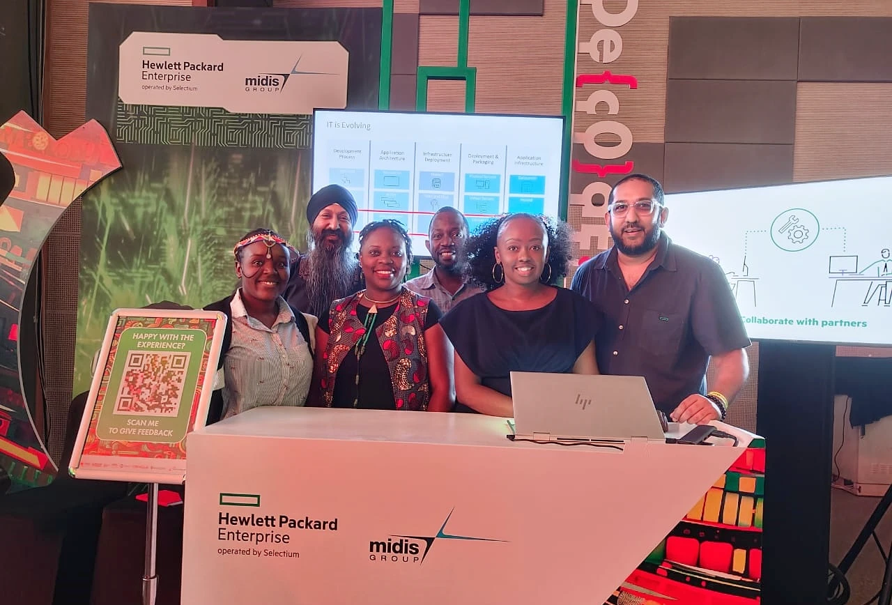 six people are seen in a group shot at a conference stand