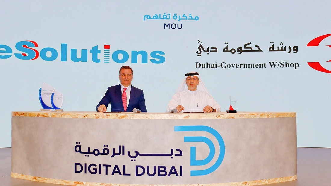 two men are seen at a desk signing an agreement