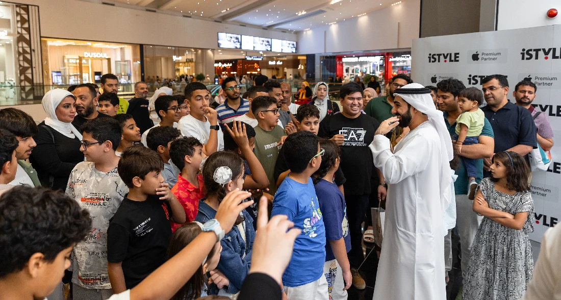 a man in white entertains a large group of young people