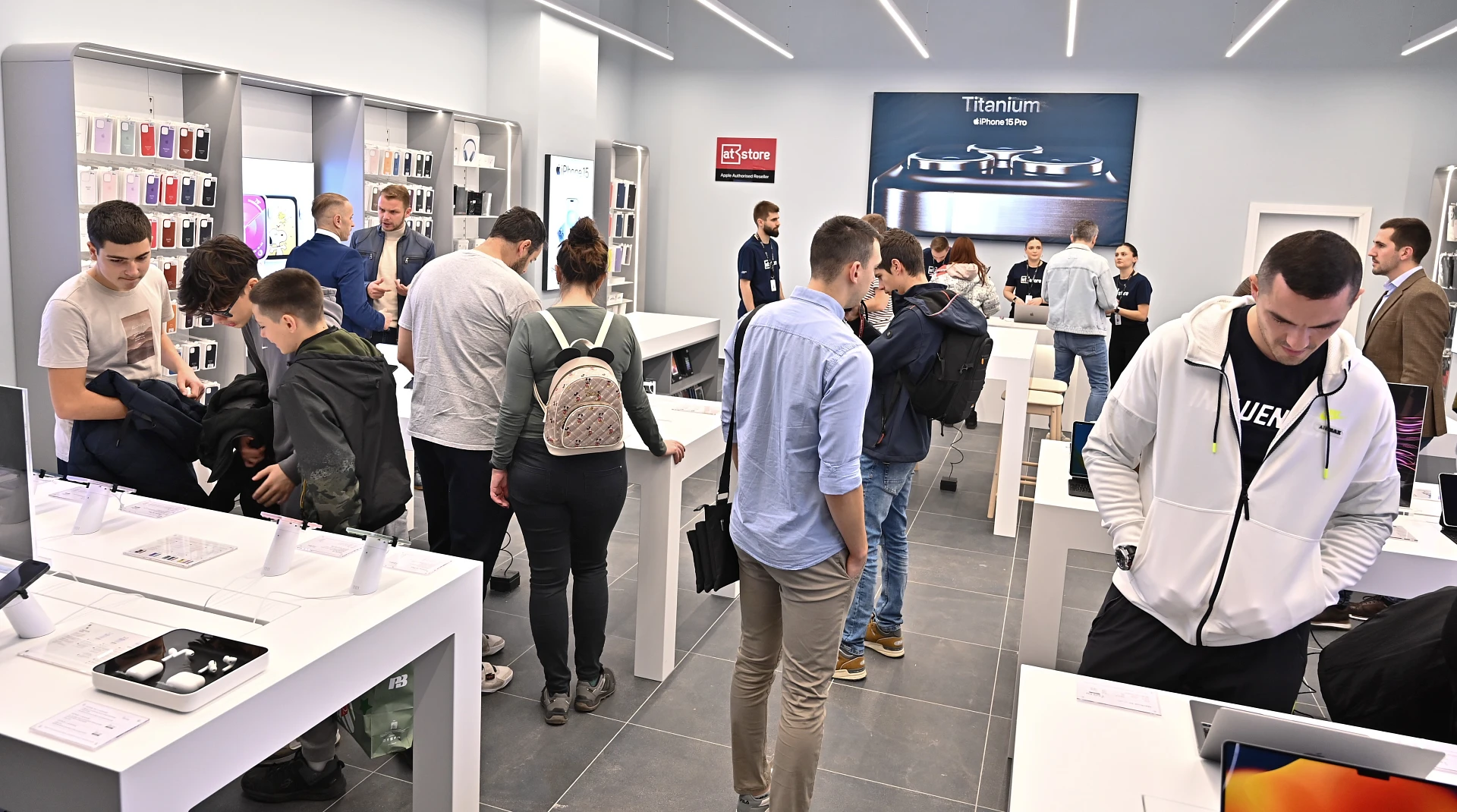 people are seen inside a hi tech store looking at Apple products
